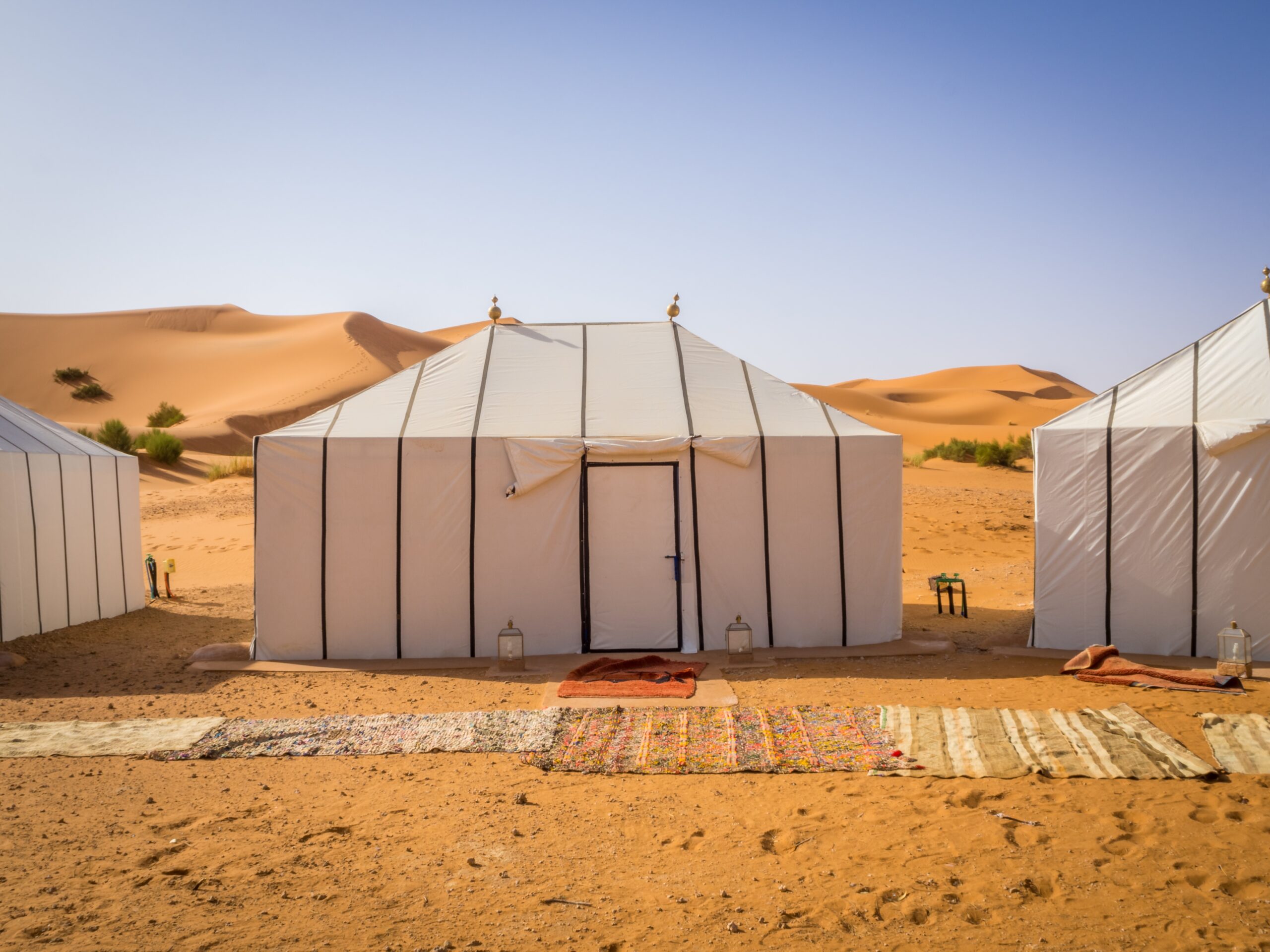 White Berber tents in the Sahara Desert, Morocco with carpets on the sandy ground